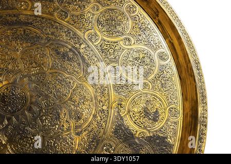 Das reich verzierte, gravierte Messingtablett mit aufwändigen Arabesken- und Blumenmotiven aus dem Nahen Osten, geprägten Kreismustern und strukturiertem Gold-Finish ist ideal Stockfoto
