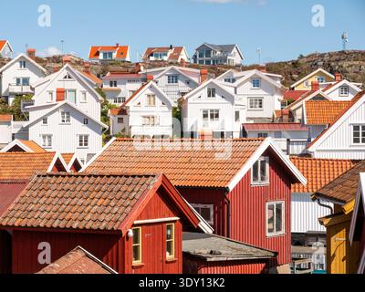 Traditionelle weiße und rote Holzhäuser mit roten Ziegeldächern im Dorf Grundsund auf der Insel Skaftö, Bohuslän, Westküste Schwedens Stockfoto