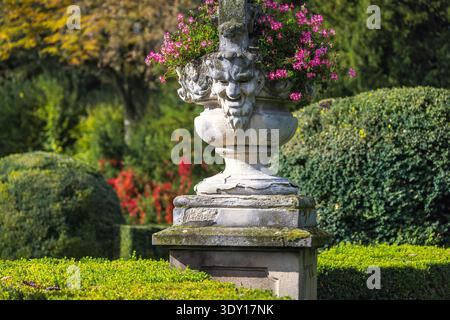 Buchlovice, Tschechische Republik - 11. Oktober 2024: Der Garten am Schloss Buchlovice. Ein kunstvoller Steintopf, voller leuchtender rosafarbener Blumen, Sta Stockfoto