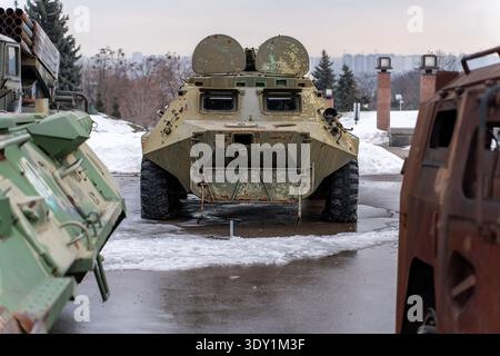 Blick auf imposante Militärfahrzeuge schweigen Sie auf kaltem, nassem Boden, und unter dem bewölkten Himmel glänzen Metall, Kiew, Ukraine. Stockfoto