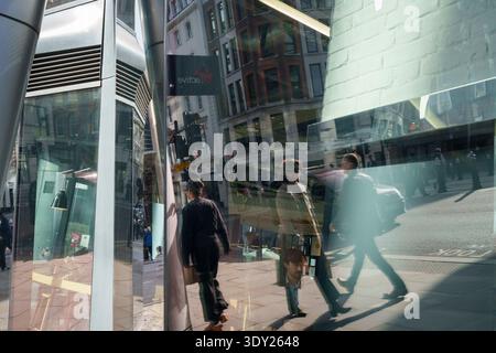 Fußgänger und Passanten spazieren am 5. März 2026 in London, England, durch ein Stadtbild aus Licht, Schatten und Glasreflexionen. Stockfoto