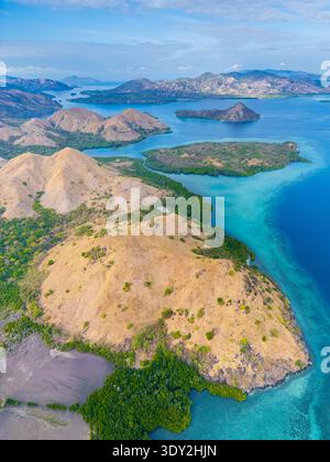 Bei einem atemberaubenden Blick aus der Luft auf den Komodo-Nationalpark in Indonesien zeigt sich türkisfarbenes Wasser mit üppigen Inseln in einem lebendigen Wandteppich der Natur Stockfoto