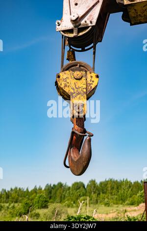 Schwerer Industriekrane mit Haken- und Riemenscheibensystem vor klarem blauem Himmel Stockfoto