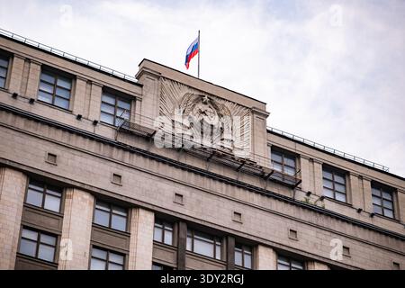 Russische Flagge über dem Gebäude der Staatsduma mit Wappenrelief der UdSSR, Moskau Stockfoto