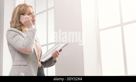 Erfolgreiche Geschäftsfrau auf der Arbeit, die am Telefon spricht Stockfoto