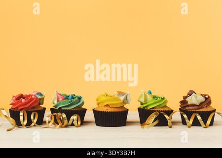 Schokoladen-Cupcakes in Folge mit farbenfroher Glasur Stockfoto