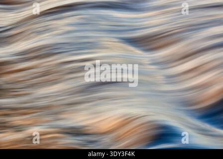 Ein abstraktes Hintergrundbild mit verschwommenen, fließenden Linien und sanften Wellen in Blau-, Braun-, weiß- und Cremetönen. Crea für den Langzeitbelichtungseffekt Stockfoto