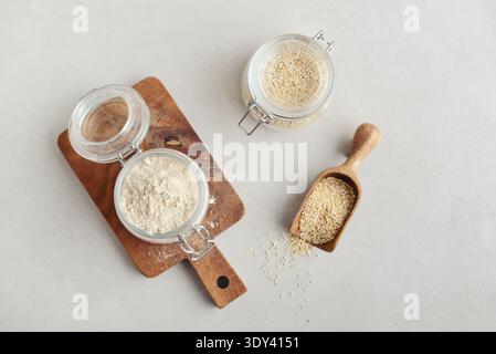 Amaranth Mehl in Glasgefäß mit roher Amaranth auf hellem Hintergrund, Draufsicht Stockfoto