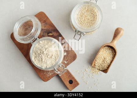 Amaranth Mehl in Glasgefäß mit roher Amaranth auf hellem Hintergrund, Draufsicht Stockfoto