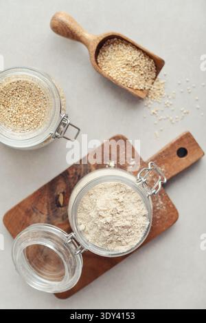 Amaranth Mehl in Glasgefäß mit roher Amaranth auf hellem Hintergrund, Draufsicht Stockfoto