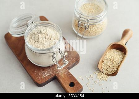 Amaranth Mehl im Glas mit roher Amaranth auf hellem Hintergrund, Nahaufnahme Stockfoto