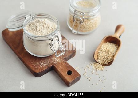 Amaranth Mehl im Glas mit roher Amaranth auf hellem Hintergrund, Nahaufnahme Stockfoto