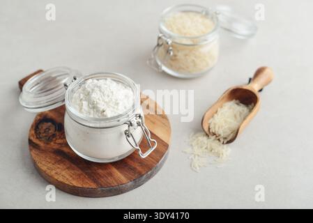 Reismehl im Glas mit roher Amaranth auf hellem Hintergrund, Nahaufnahme Stockfoto