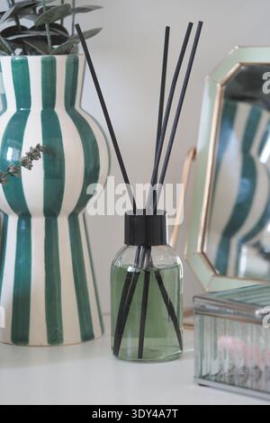 Dekorative Vase und Diffusor mit Schilfstäben auf einem Tisch Stockfoto