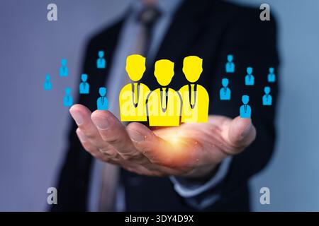 Nahaufnahme eines Geschäftsmannes mit einem leuchtenden Symbol für Personalwesen, mit hervorgehobenen Mitarbeitern im Zentrum, die Rekrutierung, Führung und Teamarbeit symbolisieren Stockfoto