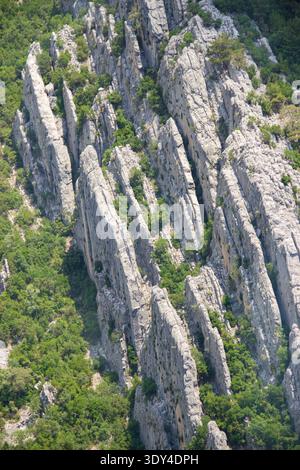 Scharfe Kalksteinformationen und Klippen an den bewaldeten Hängen des Mount Tahtali im Taurusgebirge in der Nähe von Kemer, Türkei. Stockfoto