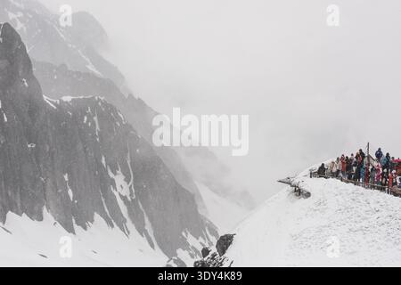 LIJIANG, YUNNAN, CHINA - 12. APRIL 2025: Touristen versammeln sich auf einer schneebedeckten Aussichtsplattform des Jade Dragon Snow Mountain, um Fotos zu machen Stockfoto