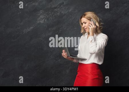 Nachdenkliche Geschäftsfrau, die im Studio telefoniert Stockfoto