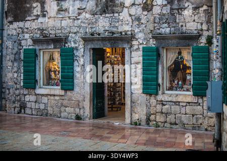 Nahaufnahme eines traditionellen Steinladens mit lebhaften grünen Fensterläden in der Altstadt von Kotor, Montenegro Stockfoto