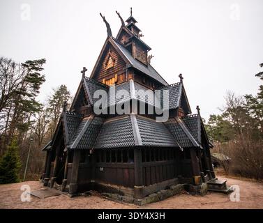 Geschnitzte Holztexturen und geteerte Kiefernschindeln der mittelalterlichen Gol Stave Kirche im Norsk Folkemuseum in Oslo, Norwegen, vor einem bewölkten Winterhimmel. Stockfoto