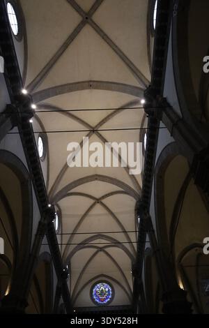 Ansicht von symmetrischen Steingewölben und Bögen in einer historischen Kirche nach oben, wobei Geometrie, Struktur und architektonischer Rhythmus betont werden. Stockfoto