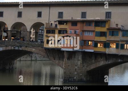 Detaillierter Blick auf farbenfrohe Wohnfassaden und Balkone entlang einer historischen Brücke Ponte Vecchio, die Textur, Maßstab und Handwerkskunst hervorhebt. Stockfoto