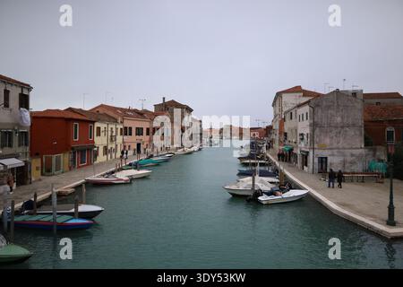 Breiter Kanal, gesäumt von historischen Gebäuden und festgemachten Booten auf der Insel Murano. Stockfoto