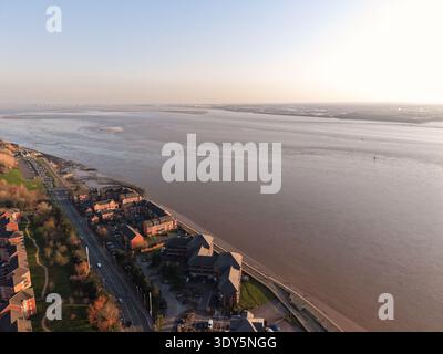Aus der Vogelperspektive des River Mersey mit Blick auf das Ufer von Liverpool mit Industriegebäuden und breitem Gezeitenwasser. Stockfoto