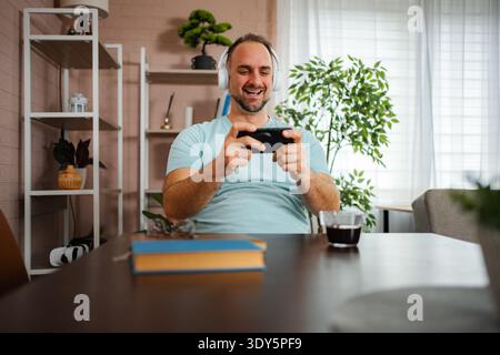 Mann, der in Innenräumen mit Kopfhörern unterwegs ist Stockfoto