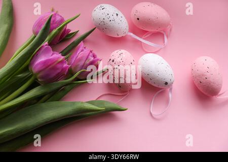 Frühlingstulpen mit eierförmigem Dekor auf rosa Hintergrund Stockfoto