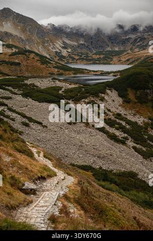Der Steinwanderweg schlängelt sich durch eine felsige Berglandschaft Stockfoto