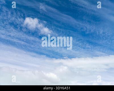 Riesiger blauer Himmel voller weicher, schimmernder Wolken. Sanfte weiße Formationen ziehen über tiefe azurblaue Weiten. Eine ruhige Atmosphäre ruft Ruhe, Ruhe und Ruhe hervor Stockfoto