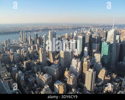 Eine Hochwinkelperspektive fängt die dichte Skyline von Midtown Manhattan mit zahlreichen modernen Wolkenkratzern ein, die sich über dem Stadtgitter erheben. Stockfoto