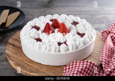 Frischer Erdbeerkuchen mit Sahne auf Holztisch Stockfoto