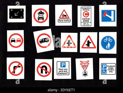 Moderne Straßen- und Verkehrsschilder aus dem Vereinigten Königreich isoliert auf schwarzem Hintergrund. Stockfoto