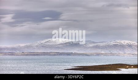 Schneebedeckte Hügel veranschaulichen die weite offene Leere des schottischen Highlands. Westlich von der Küste bei Ganavan Sands, Oban Stockfoto