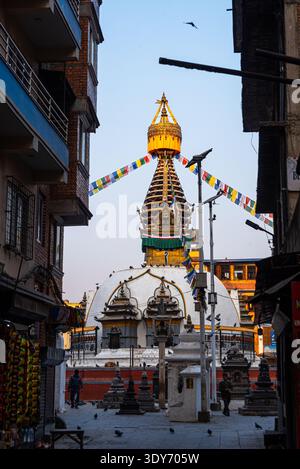 Blick auf Kathi Swoyambhu Shree GHA Stupa durch eine enge Gasse mit Gebetsfahnen in Kathmandu Stockfoto