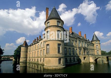 Erkunden Sie die Architektur des Schlosses von Haroue in der Region Lothringen, Frankreich, mit umliegendem Wasser und Bäumen unter klarem Himmel Stockfoto