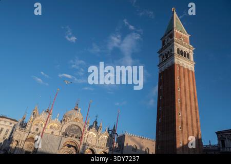 Markusbasilika und Campanile stehen auf dem Markusplatz in Venedig unter einem klaren blauen Himmel mit wenigen Wolken Stockfoto