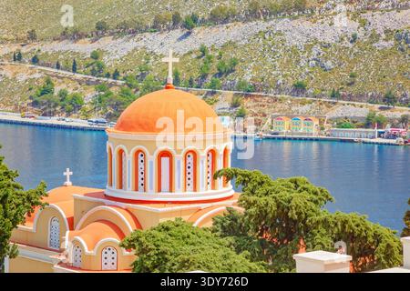 Kuppel der Evangelismos-Kirche mit Blick auf die Bucht von Gialos auf der Insel Symi in Griechenland Stockfoto