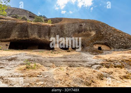 Blick auf Felseneingänge, die von Mönchen in den Einsiedlerhöhlen in Meteora genutzt wurden und antike Praktiken der Einsamkeit und Meditation in Griechenland zeigen Stockfoto