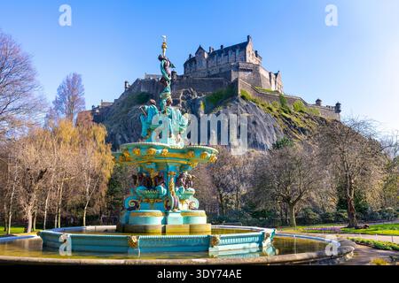 Blick auf Edinburgh Castle von Princes Street Gardens mit Ross Fountain unter einem klaren Himmel in Schottland Stockfoto