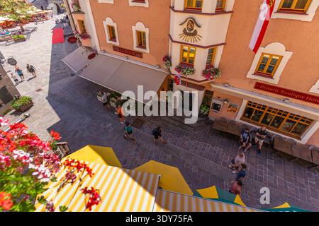 Blick auf den belebten Platz mit Geschäften und sonnigen Leuten in Zell am See, Salzburg, Österreich Stockfoto