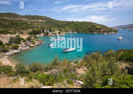 Yachten ankern in einer felsigen Bucht mit klarem türkisfarbenem Wasser in der Russian Bay nahe Poros in Griechenland Stockfoto