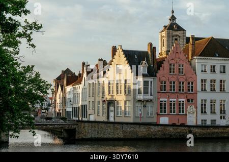 Am frühen Morgen erstrahlt Licht auf traditionelle Gebäude am Wasser in Brügge, Belgien Stockfoto
