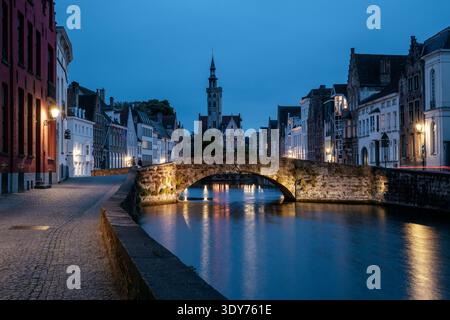 Helle Lichter reflektieren das Wasser an der Königsbrücke in Brügge, Belgien während der Dämmerung Stockfoto