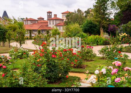 Blühende Rosen und elegante Gebäude schaffen eine schöne Szene in einem Garten in Rennes Bretagne Frankreich Stockfoto