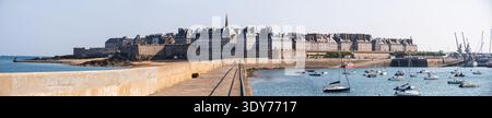 Panoramablick auf die von einer Stadtmauer ummauerte Stadt Saint-Malo und den Hafen vom MLE des Noires Pier an einem klaren Tag in Frankreich Stockfoto