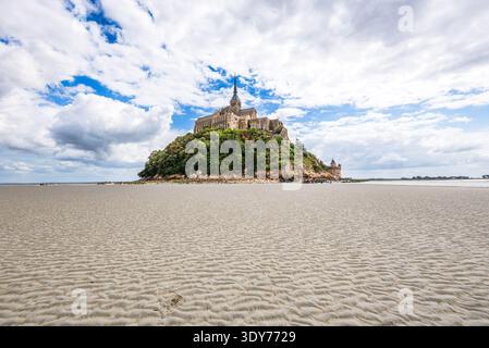 Weitwinkelansicht des Mont Saint-Michel bei Ebbe mit sandiger Landschaft und Inselfestung in Frankreich Stockfoto