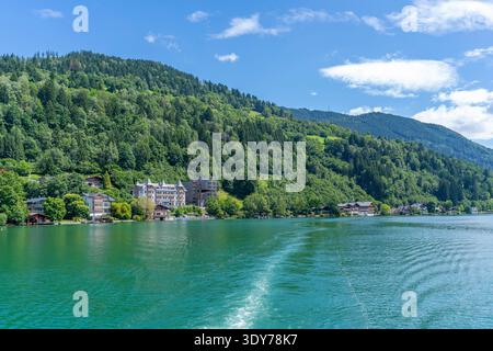 Bootstour mit Blick auf den Zeller See in Salzburg mit Gebäuden und grünen Hügeln an einem sonnigen Tag Stockfoto